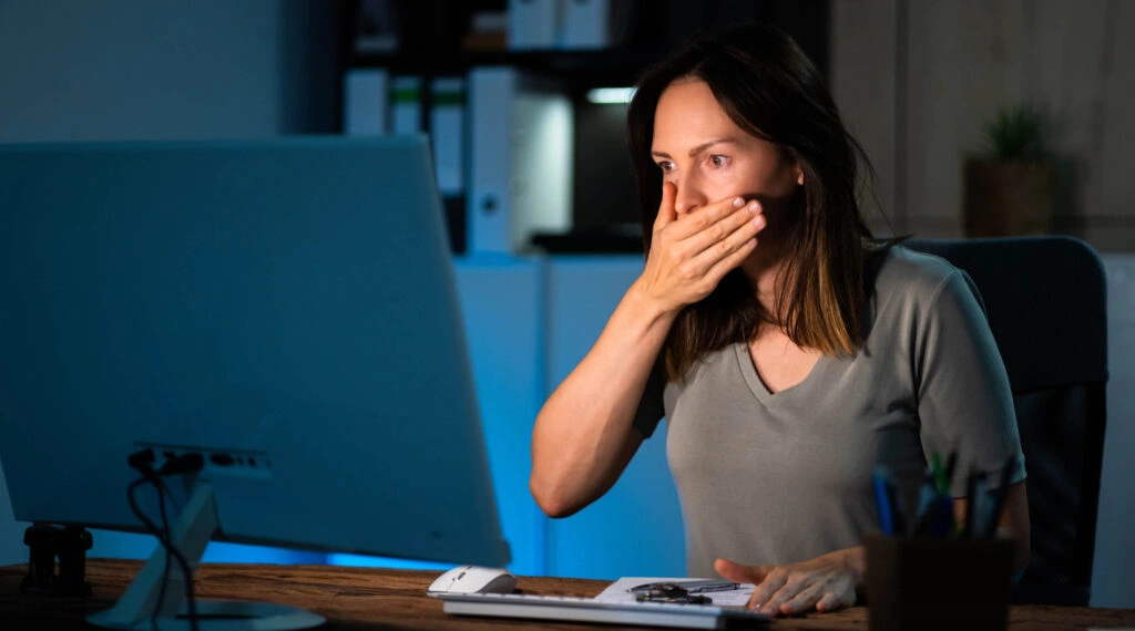Donna scioccata al computer dopo aver ricevuto una notifica di data breach, simbolo di una violazione dei dati.